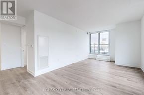 Toronto (Yorkdale-Glen Park) condo for rent - A spacious room with wooden flooring and white walls.