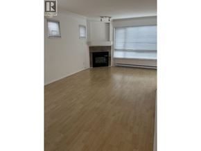 Vancouver apartment for rent - A large empty room with wooden flooring and a fireplace.