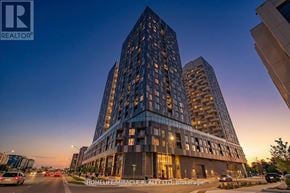 Vaughan (Concord) condo for rent - A tall building with a glass facade is illuminated from within, with the sun setting in the background.