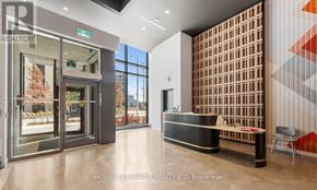 Vaughan (Concord) condo for rent - A reception area with a wooden partition and a view of the outside through the glass doors.