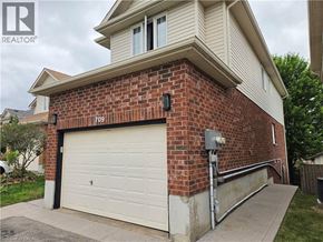 Kitchener apartment for rent - A house with a garage door and a brick wall.