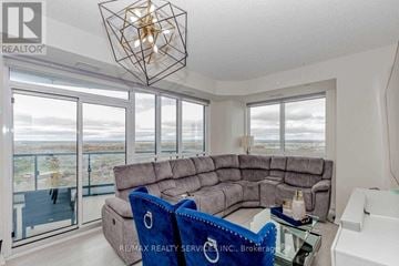 Mississauga (Hurontario) condo for rent - A living room with a grey sofa and a glass table.