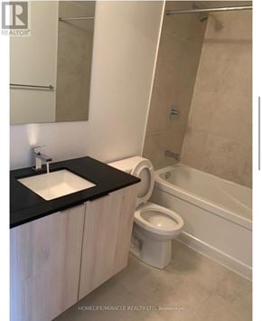 Toronto (Clanton Park) condo for rent - A white toilet sits next to a sink in a bathroom.