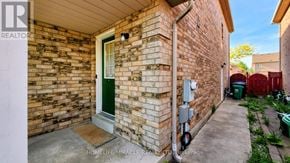 Brampton (Fletcher's Meadow) apartment for rent - A brick house with a green door and a sign that says REALTOR.