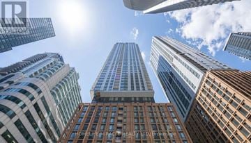 Toronto (Waterfront Communities) condo for rent - A view of a cityscape with tall buildings and a clear sky.