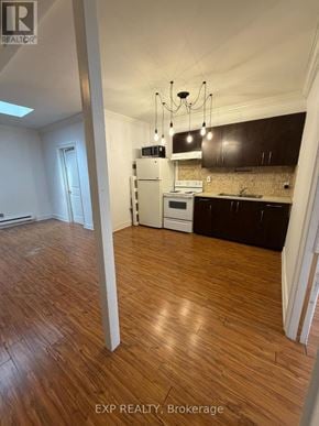 Toronto (Junction Area) multi-family for rent - A kitchen with wooden floors and a white stove top oven.