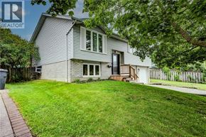 Guelph apartment for rent - A house with a grey exterior and a white fence.