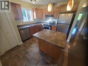 Windsor apartment for rent - A kitchen with wooden cabinets and a granite countertop.