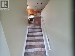 Windsor apartment for rent - A staircase with a marble patterned tread leads to a kitchen.