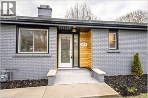 St. Catharines apartment for rent - A house with a grey exterior and a wooden front door.