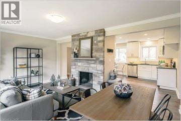 St. Catharines apartment for rent - A well-lit living room with a fireplace and a dining table set for four.
