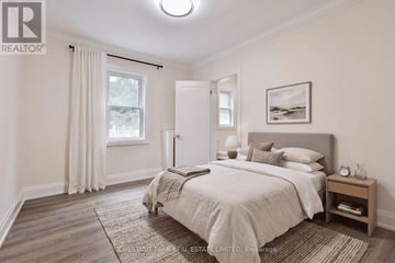 Toronto (Yonge-St. Clair) multi-family for rent - A bedroom with a large bed and a window with curtains.