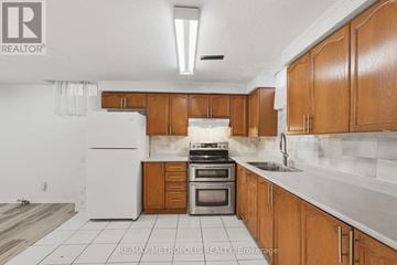 Pickering (Amberlea) apartment for rent - A kitchen with wooden cabinets and a white refrigerator.