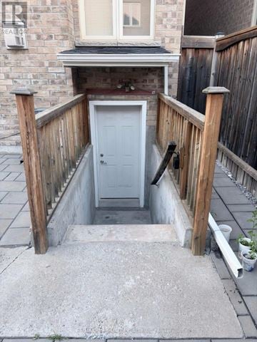 Markham (Berczy) apartment for rent - A small white door is in a concrete covered area.