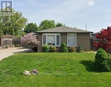 Brampton (Southgate) apartment for rent - A house with a green lawn and a red tree in the front yard.