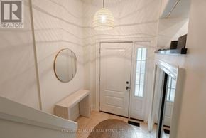 Oakville (Co Central) townhouse for rent - A white hallway with a round mirror and a light hanging from the ceiling.
