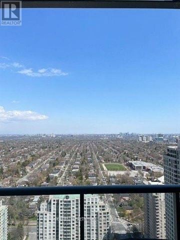 Toronto (Willowdale West) condo for rent - A cityscape with apartment buildings and a clear blue sky.