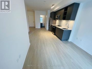 Toronto (Mount Pleasant West) condo for rent - A spacious kitchen with dark cabinets and a light wood floor.