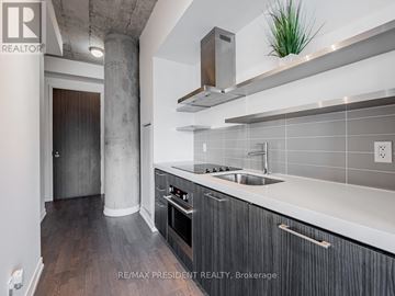 Toronto (Waterfront Communities) condo for rent - A modern kitchen with a stainless steel oven and a white countertop.
