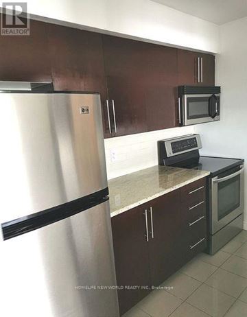 Toronto (Bendale) condo for rent - A kitchen with brown cabinets and a stainless steel refrigerator.