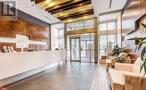 Toronto (Bendale) condo for rent - A modern office lobby with a wooden reception desk and a glass door leading to the outside.
