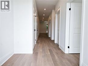 Hamilton apartment for rent - A long hallway with white walls and wood flooring.
