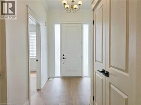Hamilton apartment for rent - A hallway with a white door and a chandelier.