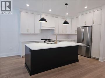 Hamilton apartment for rent - A kitchen with white cabinets and a black island.