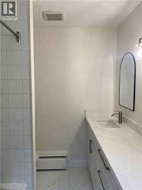 Kitchener apartment for rent - A white bathroom with a sink and mirror.