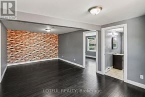 Ottawa triplex for rent - A room with a brick wall and wooden flooring.