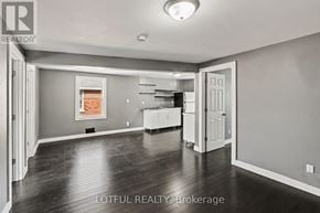 Ottawa triplex for rent - A spacious room with a kitchen area in the background.