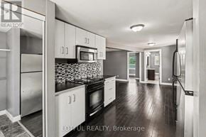 Ottawa triplex for rent - A modern kitchen with stainless steel appliances and white cabinets.