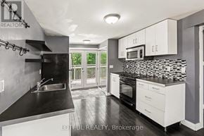 Ottawa triplex for rent - A modern kitchen with a black countertop and white cabinets.