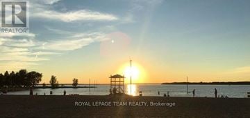 Ottawa townhouse for rent - A sunset view with a lifeguard tower in the foreground and people enjoying the beach.