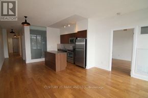 Toronto (High Park North) condo for rent - A kitchen with wooden floors and a refrigerator.