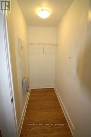 Toronto (High Park North) condo for rent - A long hallway with a door on the left and a white wall on the right.