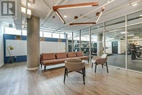Toronto (St. Andrew-Windfields) townhouse for rent - A modern office space with a long brown sofa and two chairs.