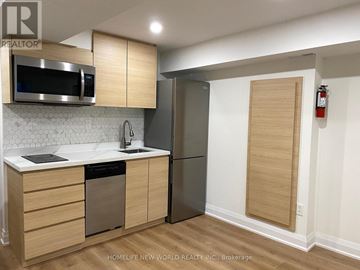 Toronto (Moss Park) triplex for rent - A kitchen with wooden cabinets and a stainless steel refrigerator.