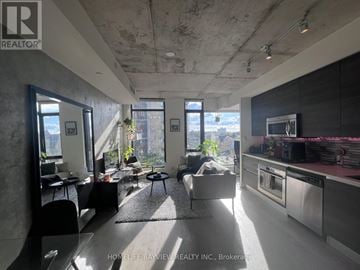 Toronto (Waterfront Communities) condo for rent - A modern kitchen with a large island and a view of the city.