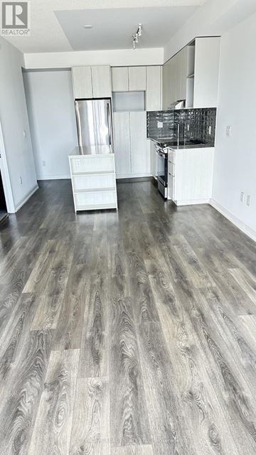 Mississauga (Erin Mills) condo for rent - A spacious kitchen with white cabinets and a wooden floor.