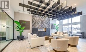 Milton (Co Coates) condo for rent - A modern living room with a glass door, a white sofa, and a plant.