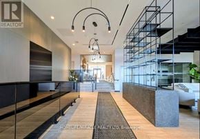 Milton (Co Coates) condo for rent - A modern interior space with a long hallway and a staircase on the right side.