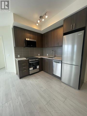Milton (Co Coates) condo for rent - A modern kitchen with dark wood cabinets and stainless steel appliances.