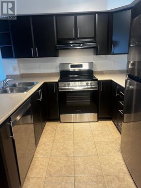 Burlington (Alton) condo for rent - A kitchen with black cabinets and stainless steel appliances.