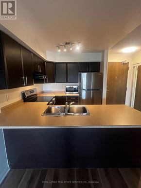 Burlington (Alton) condo for rent - A kitchen with a stainless steel refrigerator and a sink.