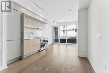 Mississauga (City Centre) condo for rent - A spacious kitchen with white cabinets and a view of a construction site outside the window.