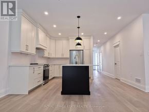 Hamilton (Gourley) apartment for rent - A spacious kitchen with white cabinets and a black island.