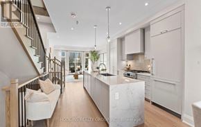 Mississauga (Mineola) townhouse for rent - A modern kitchen with a marble island and a staircase with wooden railings.