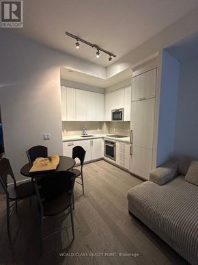 Toronto (Waterfront Communities) condo for rent - A modern kitchen with a dining table and chairs.