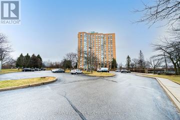 Toronto (Guildwood) condo for rent - A tall apartment building is situated in a parking lot.